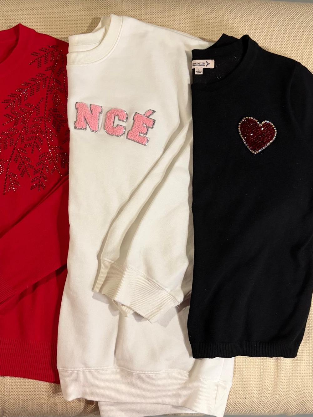 A group of 3 women’s sweaters